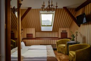 a bedroom with a bed and two chairs and a window at Gerlóczy Boutique Hotel in Budapest