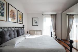 een slaapkamer met een groot bed met witte lakens bij Santa Caterina Apartment by Wonderful Italy in Bologna