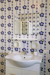 a blue and white bathroom with a sink and a mirror at Casa Barca - Le chiavi degli Iblei in Punta Braccetto +19 photos