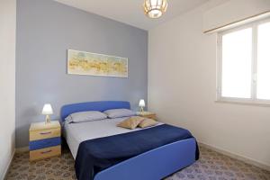 a bedroom with a blue bed and a window at Casa Barca - Le chiavi degli Iblei in Punta Braccetto
