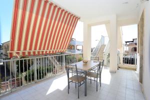 a patio with a table and chairs on a balcony at Casa Barca - Le chiavi degli Iblei in Punta Braccetto