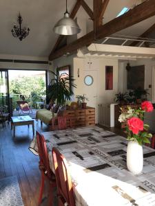 - une salle à manger avec une table et des fleurs dans l'établissement Le Bayanas, à La Rochelle