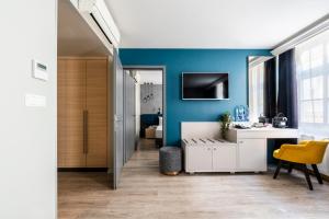 Habitación con pared azul y escritorio blanco. en Alta Moda Fashion Hotel en Budapest