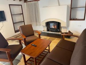 un soggiorno con divano e camino di Omodos Katoi Holiday Homes a Omodos