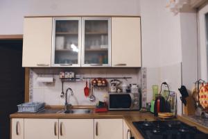 a kitchen with white cabinets and a sink and a microwave at APARTMENTS KRAPEC in Ježdovec +12 photos