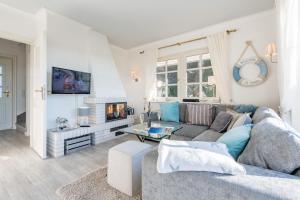 a living room with a couch and a fireplace at Ferienhaus Weitblick in Morsum