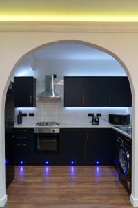 an archway in a kitchen with a stove top oven at Kitchener house in Leeds