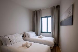 Habitación de hotel con 2 camas y ventana en NC APARTMENTS RAMBLA3, en Figueres