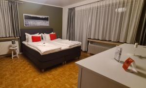 a hotel room with a bed with red pillows at Schollers Restaurant & Hotel in Rendsburg