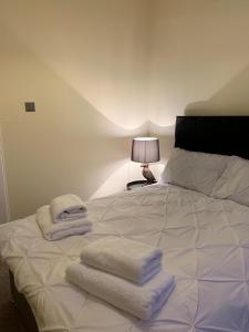 a bedroom with a white bed with towels on it at clyde hub in Gourock
