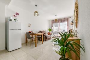 cocina y sala de estar con nevera y mesa en Apartamentos Zafiro Atico (3-12º-C), en Calpe
