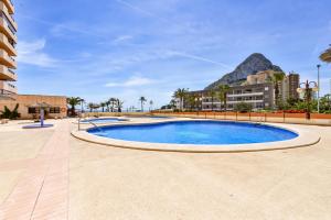 una piscina en un complejo con una montaña en el fondo en Apartamentos Zafiro Atico (3-12º-C), en Calpe