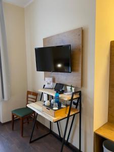 a room with a desk with a tv on a wall at Altstadt Hotel in Potsdam