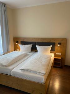 ポツダムにあるアルトシュタット ホテルのベッドルーム1室(白いシーツが備わるベッド2台付)