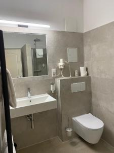 a bathroom with a sink and a toilet and a mirror at Altstadt Hotel in Potsdam