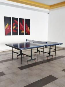 a ping pong table in a room with paintings at THE MAJESTIC IPOH B8 by ZamanJa in Ipoh