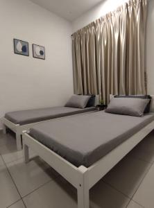 2 camas en una habitación con cortinas en THE MAJESTIC IPOH B8 by ZamanJa, en Ipoh