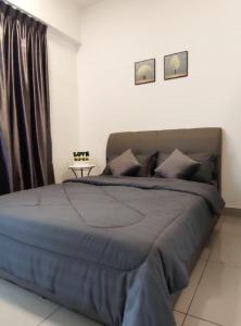 a bedroom with a large bed with a blue blanket at THE MAJESTIC IPOH B8 by ZamanJa in Ipoh