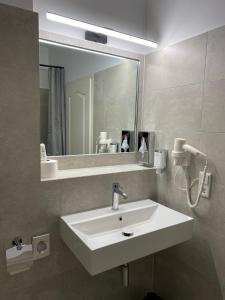 a bathroom with a white sink and a mirror at Altstadt Hotel in Potsdam