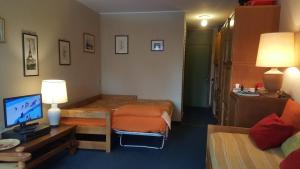 a hotel room with two beds and a television at Appartamento Flora - Val di Luce in Abetone