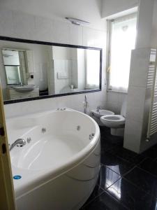 a white bathroom with a tub and a toilet at Appartamento Aurora in Florence +11 photos