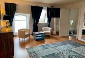ein Wohnzimmer mit zwei Stühlen und einem Tisch in der Unterkunft Villa Sturm Rüdesheim am Rhein in Rüdesheim am Rhein