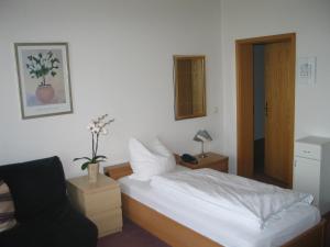 niewielka sypialnia z łóżkiem i krzesłem w obiekcie Adler Hotel Dresden w Dreźnie