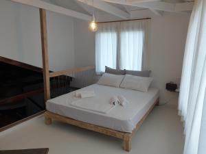 a bedroom with a bed with two towels on it at Villa Rena Agios Petros in Áyios Pétros