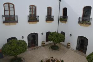 un bâtiment blanc avec des arbres devant dans l'établissement Córdoba Cool Vailima 2, à Cordoue