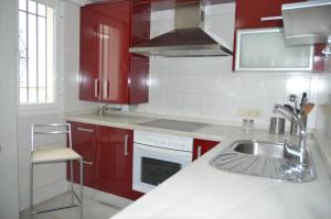 una cocina con armarios rojos y fregadero en Córdoba Cool Vailima 2 en Córdoba