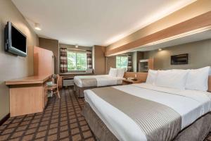 um quarto de hotel com duas camas e uma televisão em Microtel Inn & Suites by Wyndham West Chester em West Chester