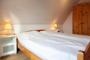 Ferienwohnung Grashof في Rettin: غرفة نوم بسرير ابيض كبير ومصباحين