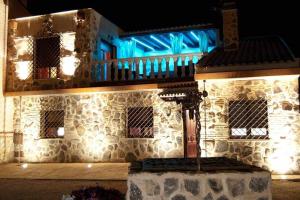- un bâtiment en pierre avec des lumières bleues dans l'établissement Casa Rural El Rosal del Pozo, a 5 minutos de Puy du Fou, à Argés