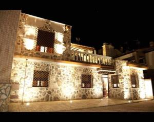 un edificio de piedra con luces encendidas por la noche en Casa Rural El Rosal del Pozo, a 5 minutos de Puy du Fou, en Argés