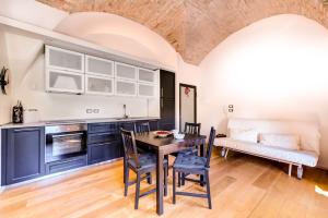 a kitchen with a table and chairs and a couch at Appartamenti a Villa Saltarelli vicino all'aeroporto in Bologna