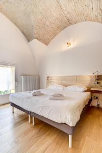 a large bed in a room with a wooden floor at Appartamenti a Villa Saltarelli vicino all'aeroporto in Bologna