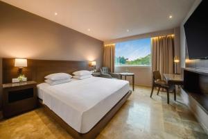 ein Schlafzimmer mit einem großen weißen Bett und einem Schreibtisch in der Unterkunft Hyatt Regency Villahermosa in Villahermosa