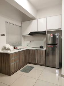 a kitchen with wooden cabinets and a stainless steel refrigerator at THE MAJESTIC IPOH B8 by ZamanJa in Ipoh