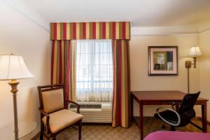 a hotel room with a desk and a window at La Quinta by Wyndham Dodge City in Dodge City +21 photos