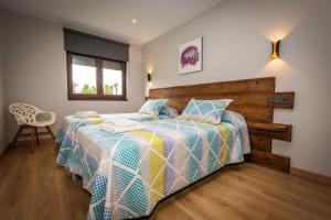 een slaapkamer met een bed met een houten hoofdeinde bij Apartamentos Casa Carin in Cadavedo