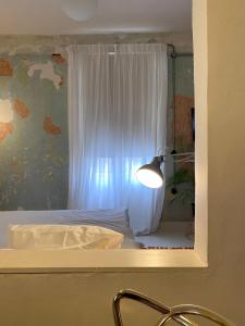 a bedroom with a bed with a white curtain and a lamp at Trilogy Experimental in Thessaloniki