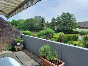 d'un balcon avec des plantes en pot et une vue sur le jardin. dans l'établissement Strandflieder, à Dornumersiel