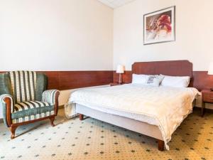 a bedroom with a large bed and a chair at Hotel Stara Garbarnia in Wrocław