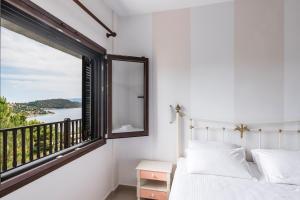 オルモス・パナギアスにあるTheoxenia Apartmentsの窓付きのベッドルーム、バルコニーが備わります。