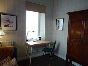 a room with a desk and a window and a chair at "la suite" in Talant