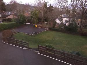 uma vista para um pátio com um banco de parque em The Brunstane Lodge em Strathpeffer