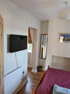 a bedroom with a bed and a flat screen tv on the wall at Bramblhen in Nottingham