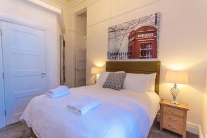 プリマスにあるThe Buckingham Suiteのベッドルーム1室(白いベッド1台、タオル2枚付)