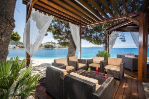 a patio with chairs and a table on the beach at Hotel Zora in Primošten