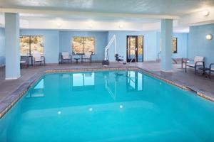 einen Pool in einem Hotel mit Tischen und Stühlen in der Unterkunft Holiday Inn Express and Suites Los Alamos Entrada Park, an IHG Hotel in Los Alamos